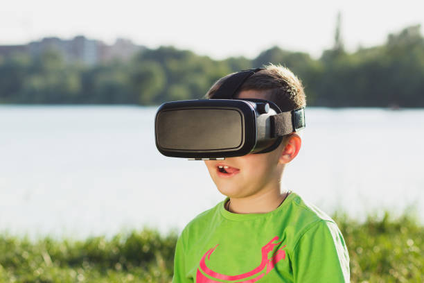 istock Boy plays game with virtual reality glasses outdoors 805378536