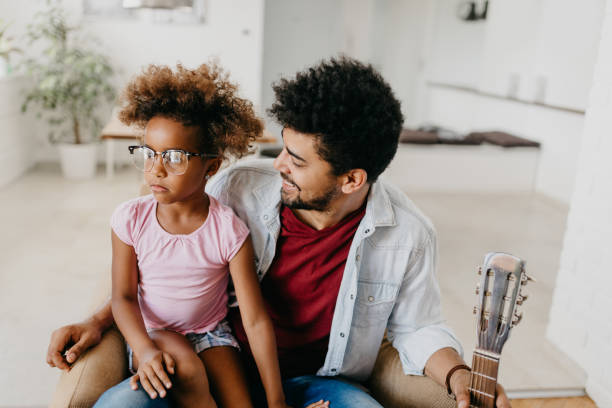 istock Kid wears father's eyewear while sitting at his lap 805416878