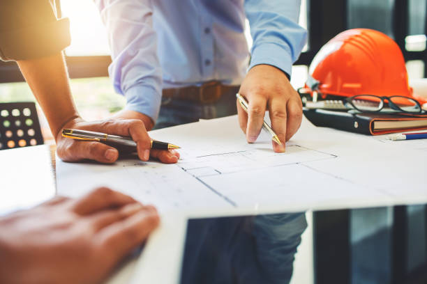 istock Architecture engineering teamwork meeting at workplace to plan drawing a new blueprint busy working hard for apartment building small business of their customer service. 805419062
