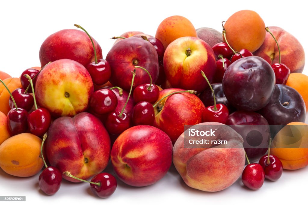 Heap ripe fruit on white Heap different fruits: cherry, peach, nectarine, apricot, plum Peach Stock Photo