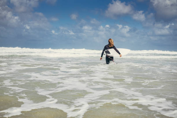 istock Male Surfer wading into the sea, Towan Beach, Newquay, Cornwall 805428270