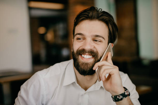 istock Smiling hipster talking on the phone at the cafe 805485136