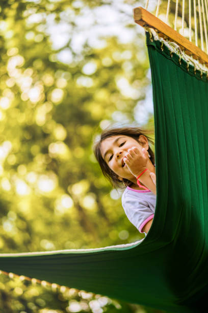 la niña de 5 años de descanso y diversión en la hamaca en el parque - child 4 5 years laughing little girls fotografías e imágenes de stock