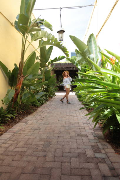 istock Woman is walking down tropical street. 805530782