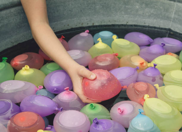 Water Balloons little girl play with colorful pastels Water Balloons (water bombs) water balloon stock pictures, royalty-free photos & images