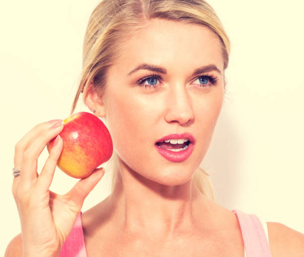 istock Happy young woman holding apple 805570002