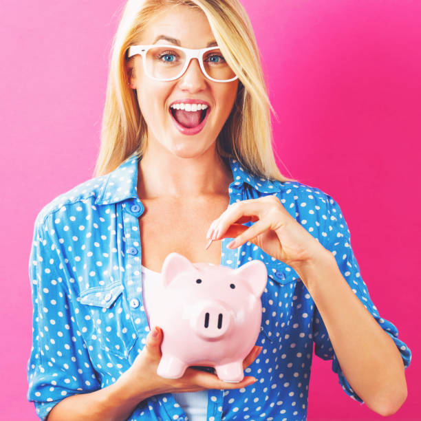 istock Young woman with a piggy bank 805575340