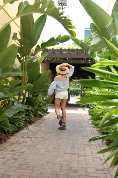 istock Woman is walking down tropical street. 805618130