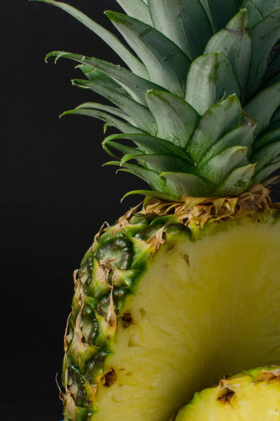 sliced pineapple fruit close up, black background stock photo