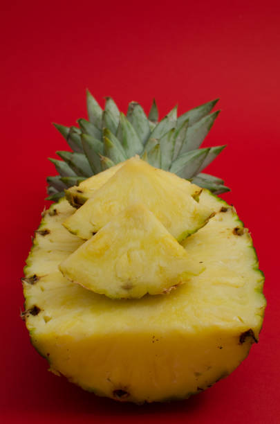 sliced pineapple fruit on red background stock photo