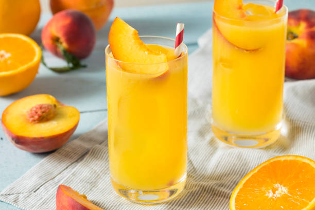 Refreshing Peach and Orange Fuzzy Navel Cocktail Refreshing Peach and Orange Fuzzy Navel Cocktail with a Garnish navel orange photos stock pictures, royalty-free photos & images