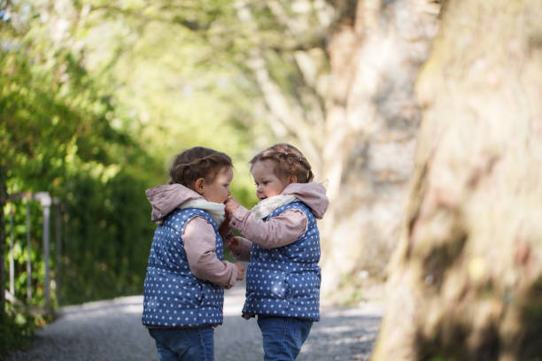 istock Identical twin girl is feeding her sister 805647140