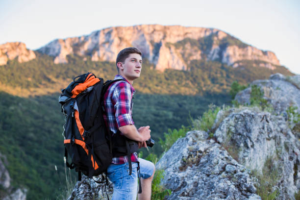 istock Cute guy hiking and taking pictures with camera 805701864