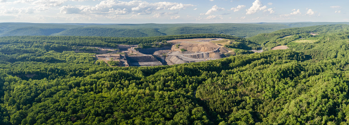 The aerial view from a drone to the open-cast mine in Lehigh Valley, Carbon County, Pennsylvania, USA. The sunny summer day. XXXL stitched panorama.