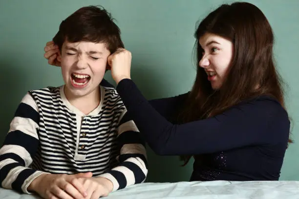 Photo of sister pull brother ear as a loss in argument