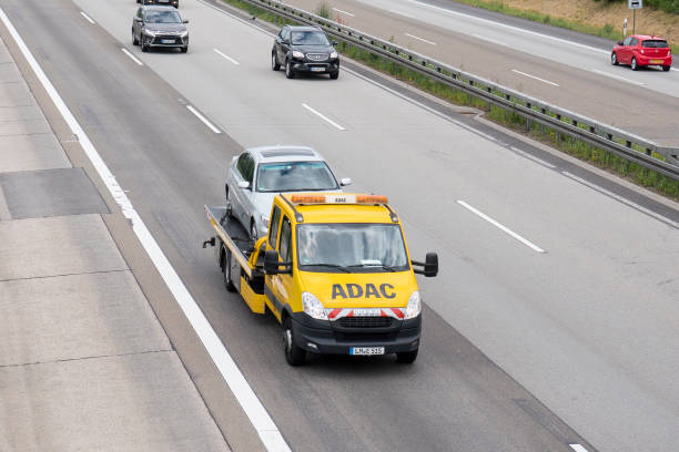 ADAC tow truck on German highway A tow truck of german ADAC Strassenwacht driving on a german highway. The ADAC (Allgemeiner Deutscher Automobil-Club) is Germany's and Europe's largest automobile club and operates a large fleet of mobile mechanics in yellow cars and tow trucks that assist motorists in trouble - the Yellow Angels. Some minor motion blur. Other road users in the background adac stock pictures, royalty-free photos & images