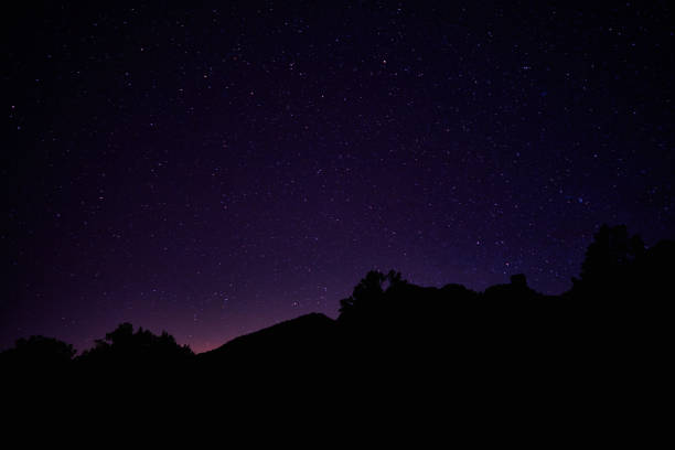 A photo of a bell tower standing under a crystal clear starry night