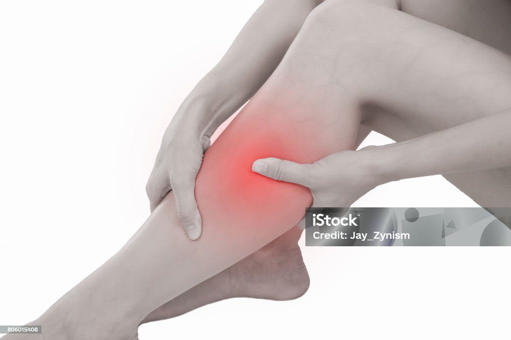 Woman with calf feeling pain on white background. Pain Stock Photo