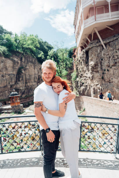 istock Guy with a girl standing on bridge 806040754
