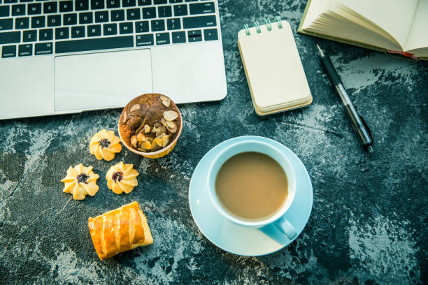 istock Cup of coffee,cake,laptop on table 806065392