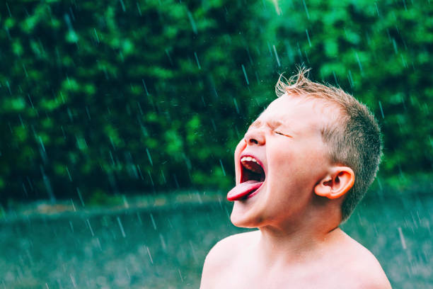夏の雨を注ぐし、少年味雨滴 - rain drenched one person standing ストックフォトと画像
