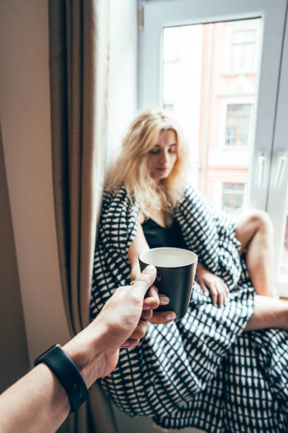 girl sitting on a window in a blanket