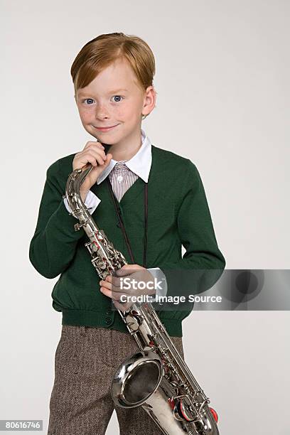 Retrato De Un Niño Sostiene Un Saxofón Foto de stock y más banco de imágenes de Actividades recreativas - Actividades recreativas, Agarrar, Alegre