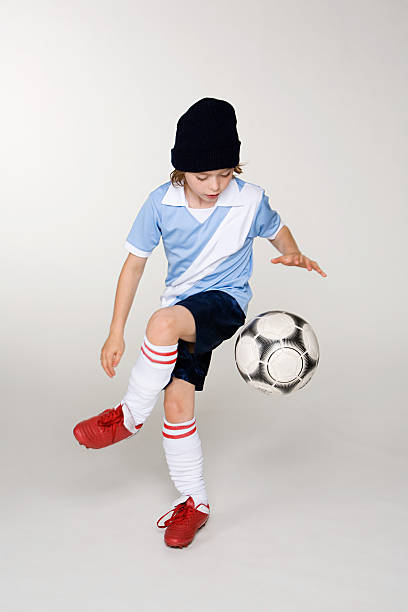 un ragazzo giocando a football - soccer child indoors little boys foto e immagini stock