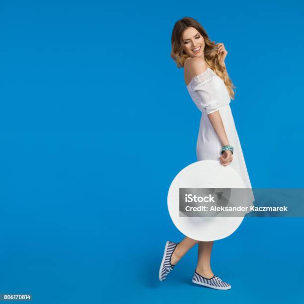 Woman In White Summer Dress Is Looking Away Over The Sholuder Stock Photo - Download Image Now