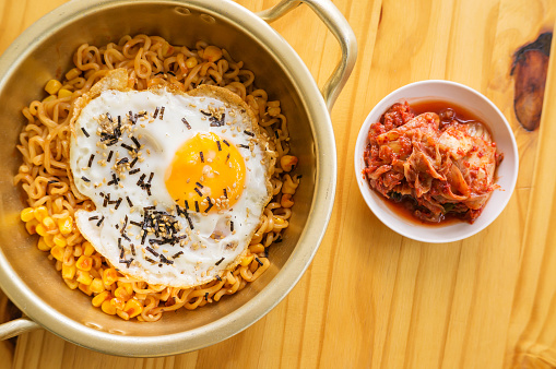 egg instant noodle and kimchi on a wooden table.
