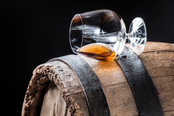 istock Glass of good cognac on oak barrel 806202340