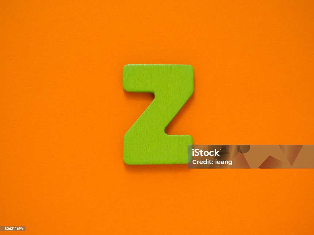 Capital letter Z. Green letter Z from wood on orange background. Arts Culture and Entertainment Stock Photo