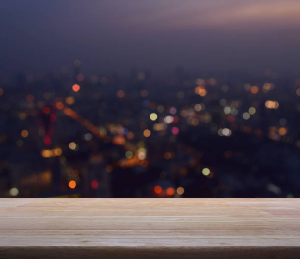 istock Empty wooden table with blurred aerial view of cityscape on warm light sundown 806220536