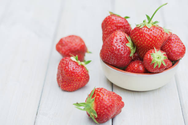 istock Bowl filled with strawberries on a wooden table 806236642