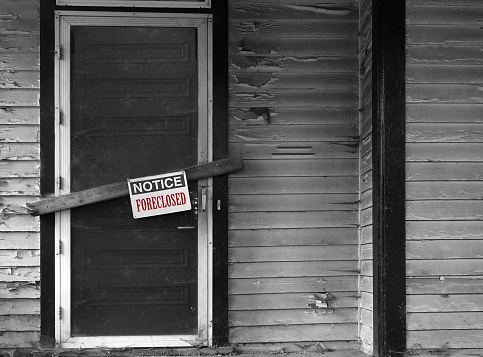 Boarded up house with Foreclosed notice on door
