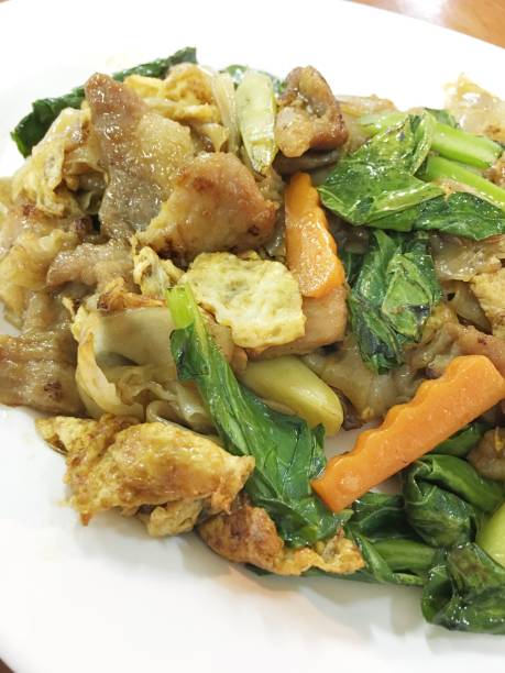 weiß auf holztisch flachen gebratene nudeln und schweinefleisch mit erhaltenen soja-bohnen-paste einrühren. thailändische küche. - tofu chinese cuisine vegetarian food broccoli stock-fotos und bilder