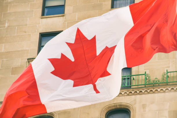 istock Big Canada flag waving in the wind with a wall in the background 806278460