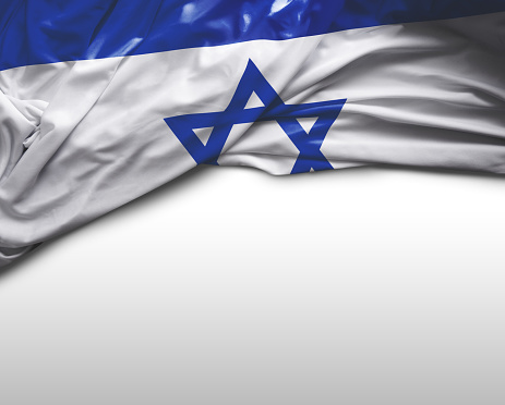 Israel flag with a star of David over cloudy sky background on sunset. Patriotic concept about Israel with national state symbols. Banner with place for text.