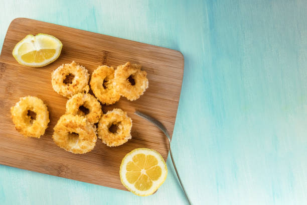 istock Calamari rings with lemon and copy space, overhead shot 806301680