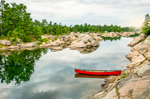 Empty red canoe floating with Georgian Bay sunset