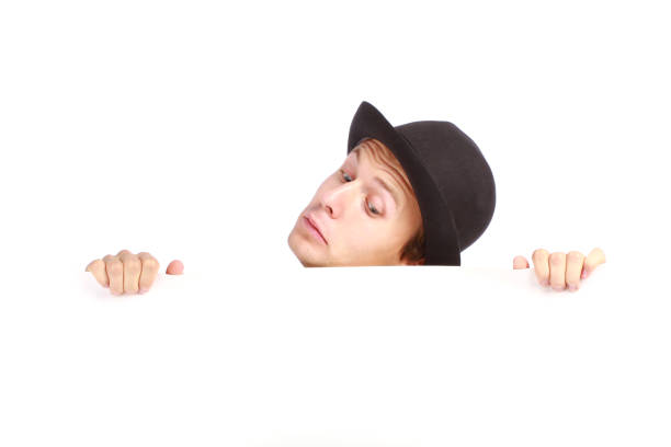 Young man hiding behind a billboard stock photo