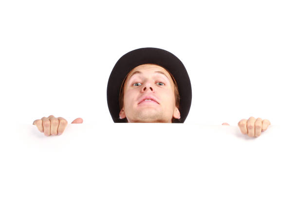 Young man hiding behind stock photo