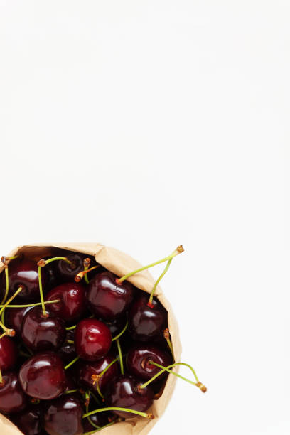 istock Fresh cherry berries in a paper bag, isolated on a white backgro 806314920