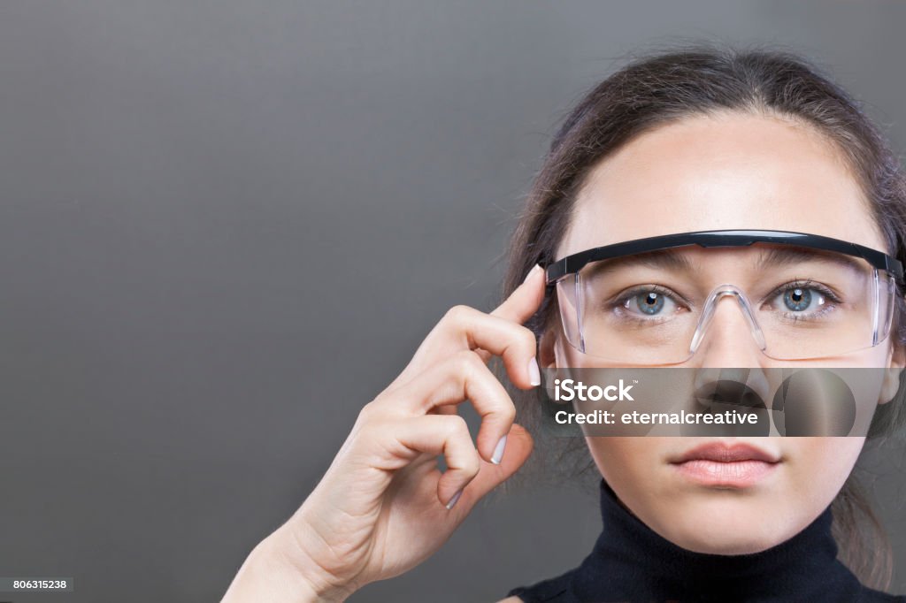 Futuristic smart glasses Young woman loking at virtual graphics in futuristic background Smart Glasses - Eyewear Stock Photo