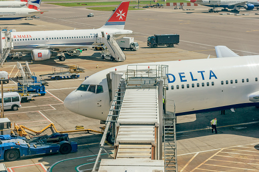 London, UK - June 05, 2008: Planes parked at the gates at Heathrow Airport. Maintenance staff are pictured