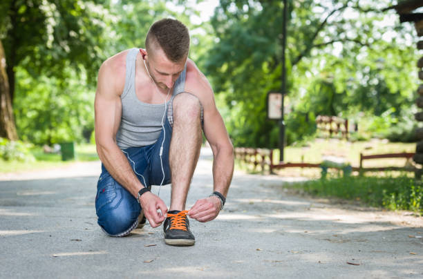 istock runner man tie shoe on a road in a park 806321006