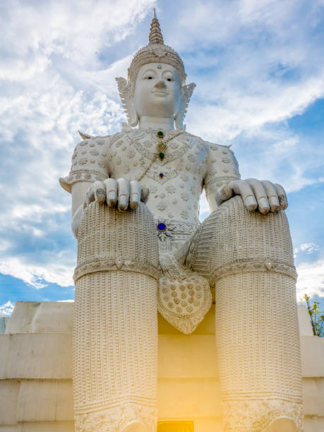 istock white Buddha statue on blue sky and rainbow 806323482