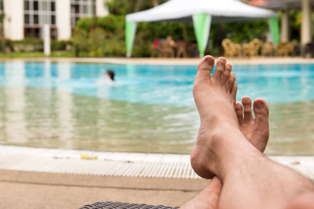 istock Man feet at swimming pool 806323522