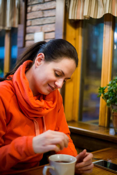 istock close up of woman adding honey to tea cup 806323906