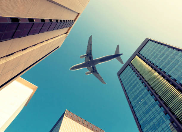 istock Plane flying over a business skyscrapers filled with offices. Filtered image: cross processed vintage effect. 806360154